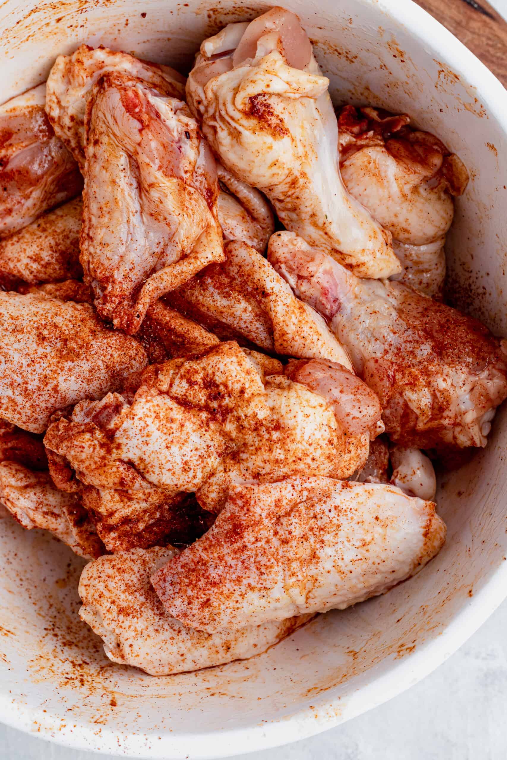 A Bowl of Raw Chicken Wings Coated in Spices