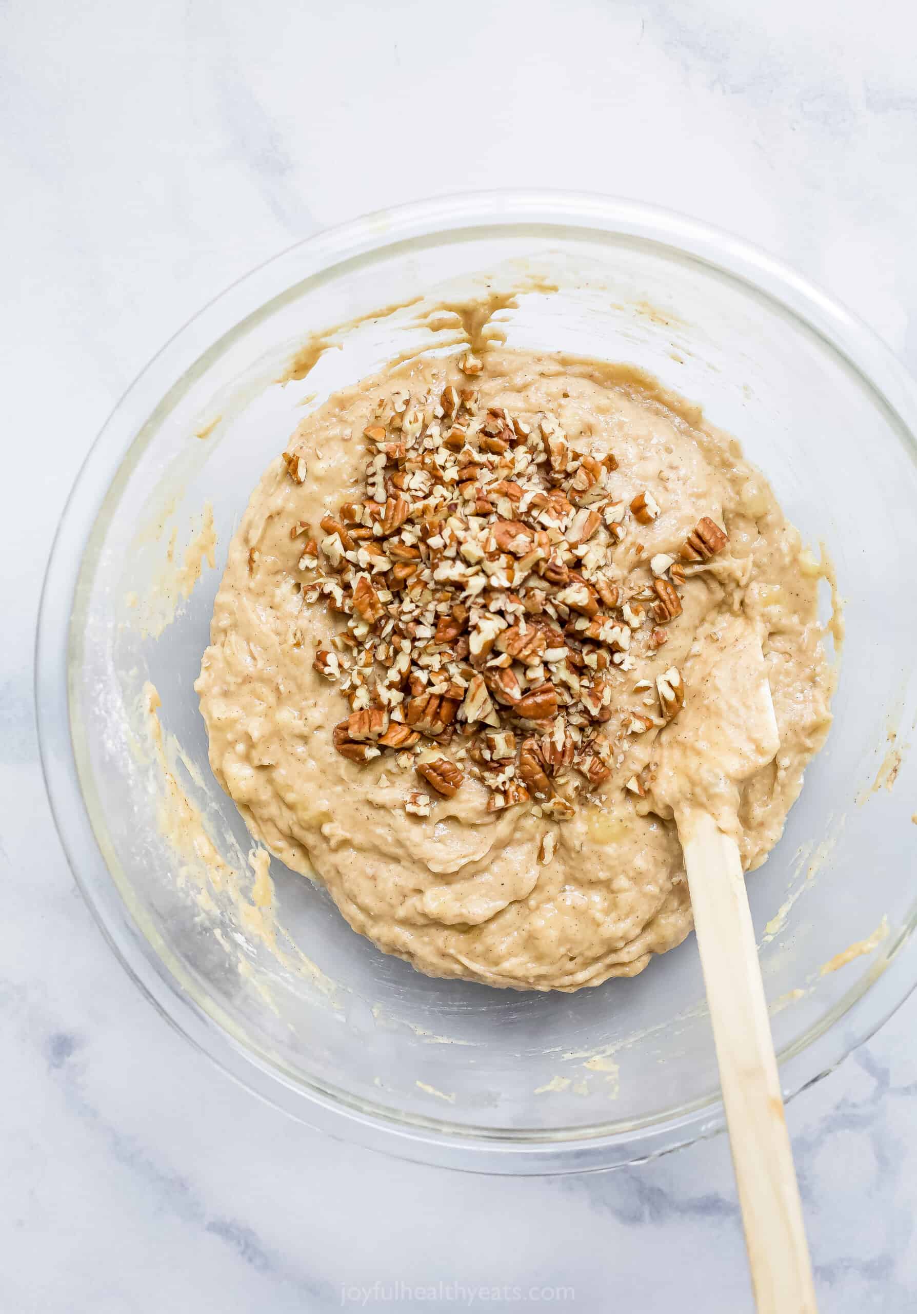 The Fully Mixed Batter in a Bowl on the Counter with Crushed Pecans Poured on Top