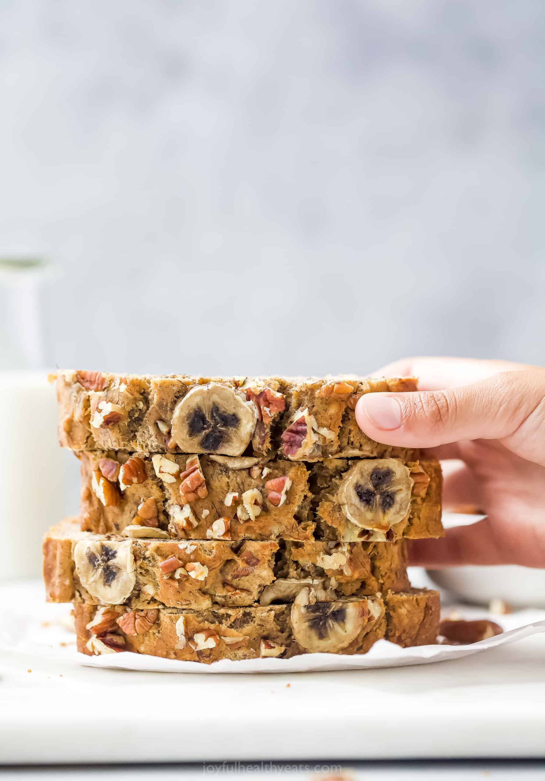 A Hand Grabbing a Piece of Homemade Bread From the Top of the Pile