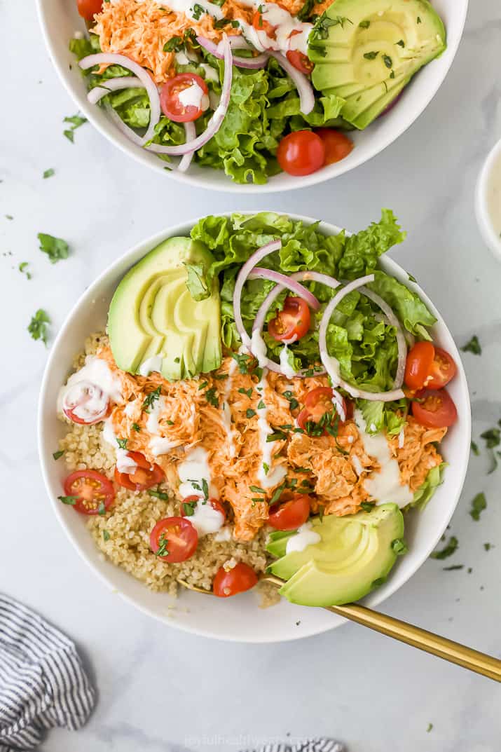 A buffalo chicken bowl sitting on a white countertop with another bowl beside it