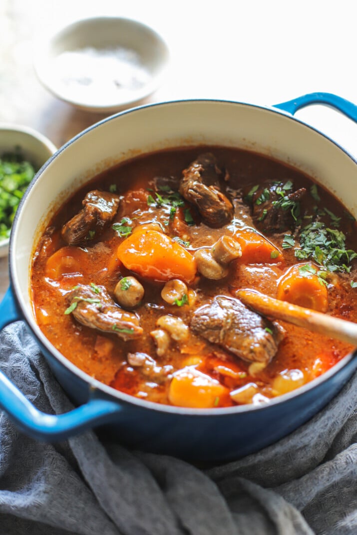 A blue crock filled with slow cooker beef bourguignon