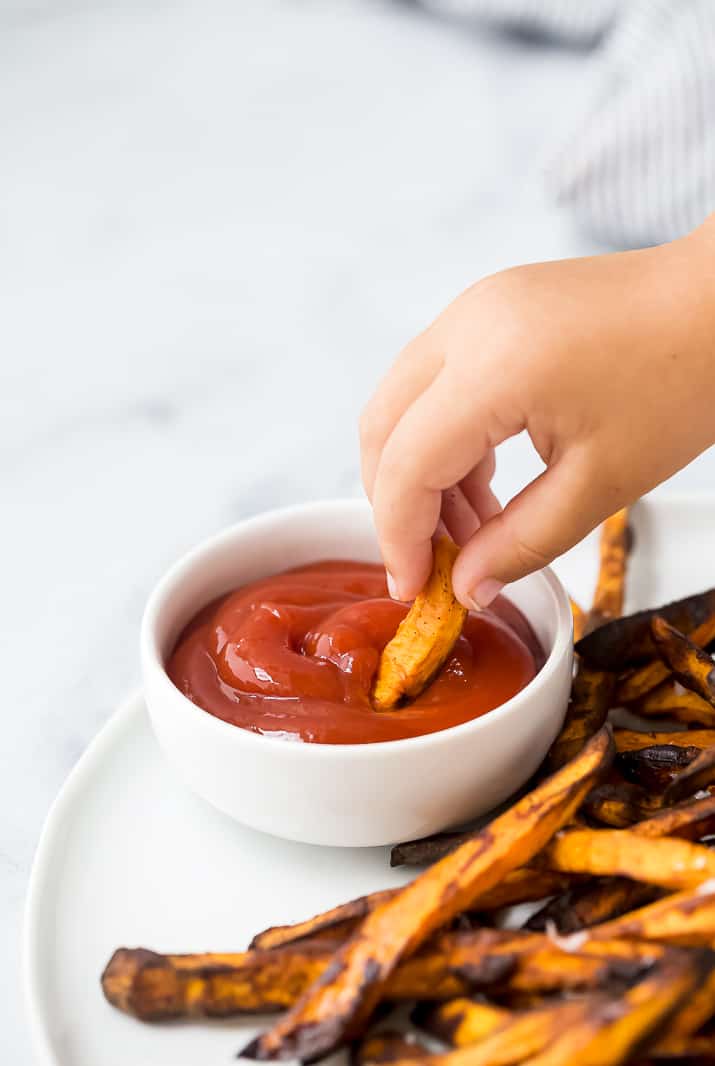 Dunking a sweet potato fry into ketchup.