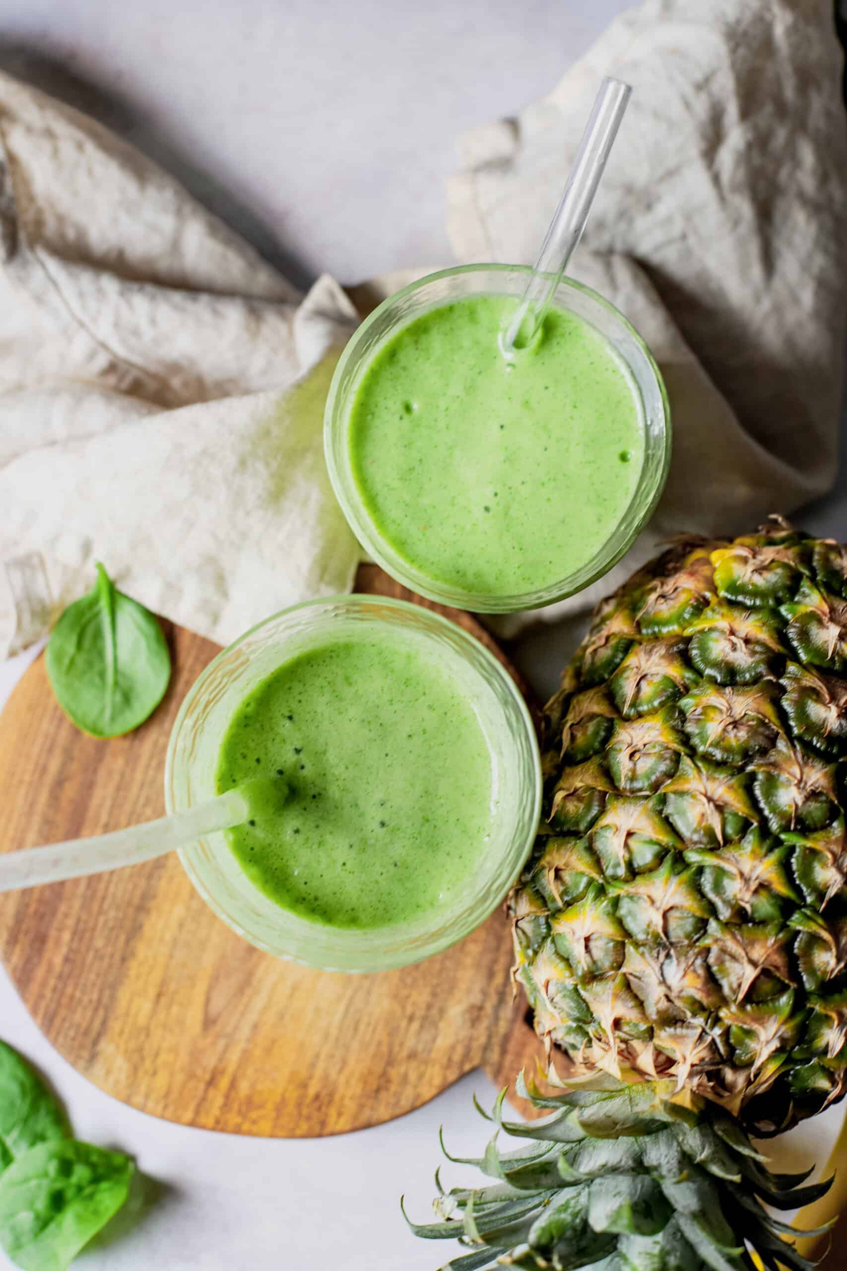 tropical green smoothie with a cup and pineapple
