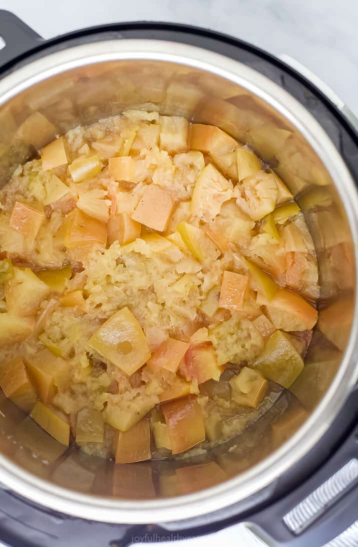 An Instant Pot filled with cooked apples, lemon juice and water
