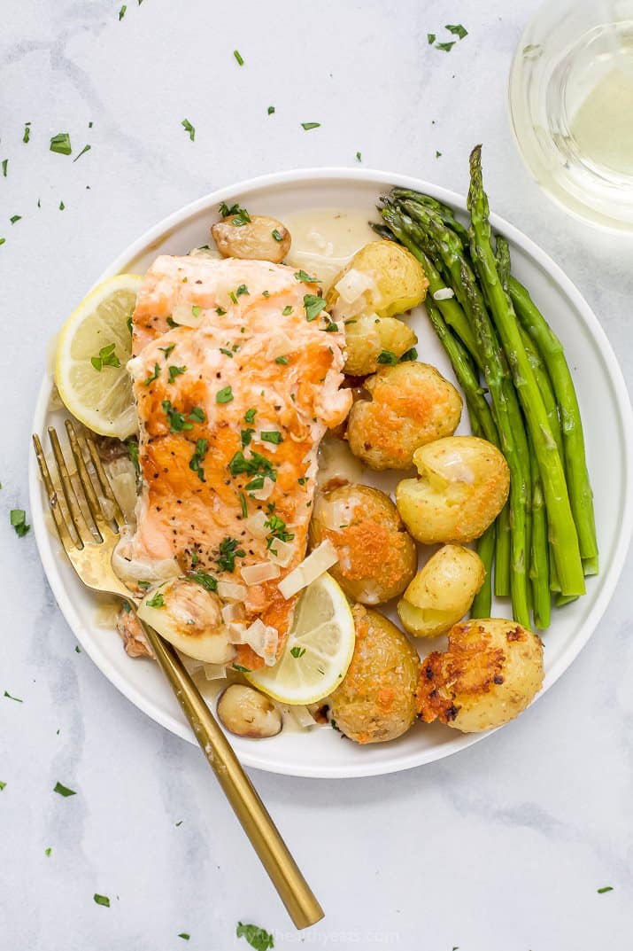 Plate of creamy salmon with asparagus and potatoes.
