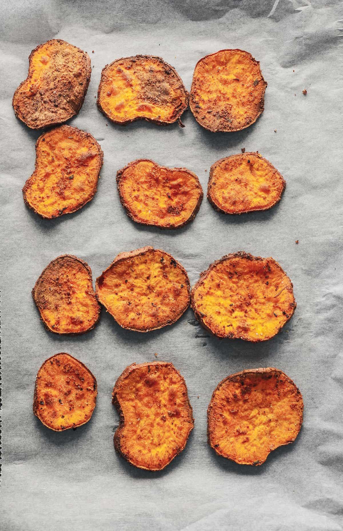 Twelve flat sweet potato fries on a baking dish lined with parchment paper