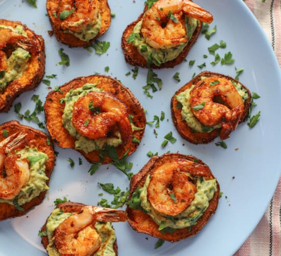 Seven shrimp appetizer bites arranged neatly on a baby blue plate