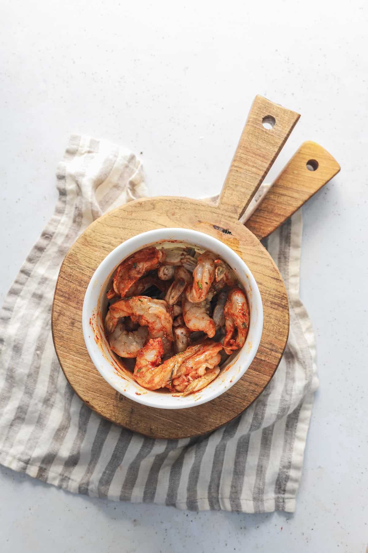 A small bowl of seasoned shrimp before it has been pan-fried