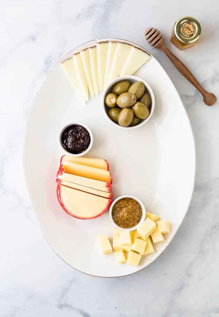 cheese board platter with cheese and condiments