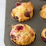 Three freshly-baked breakfast muffins inside of a metal cupcake tin
