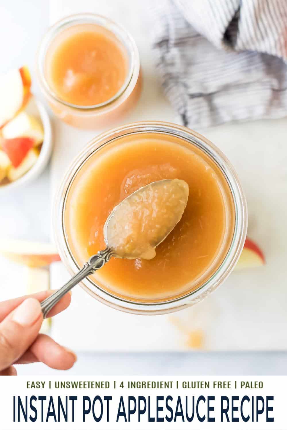 A metal spoon scooping out a bite of homemade applesauce from a jar