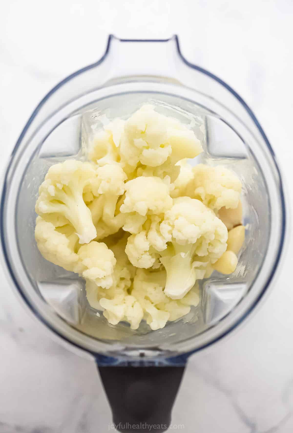 Steamed cauliflower florets inside of a food processor