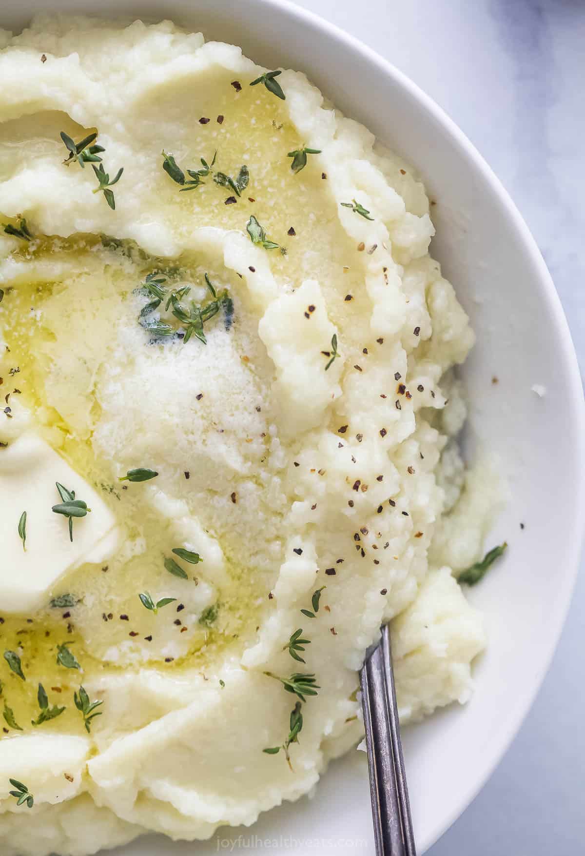 Pureed cauliflower in a white bowl on a kitchen countertop