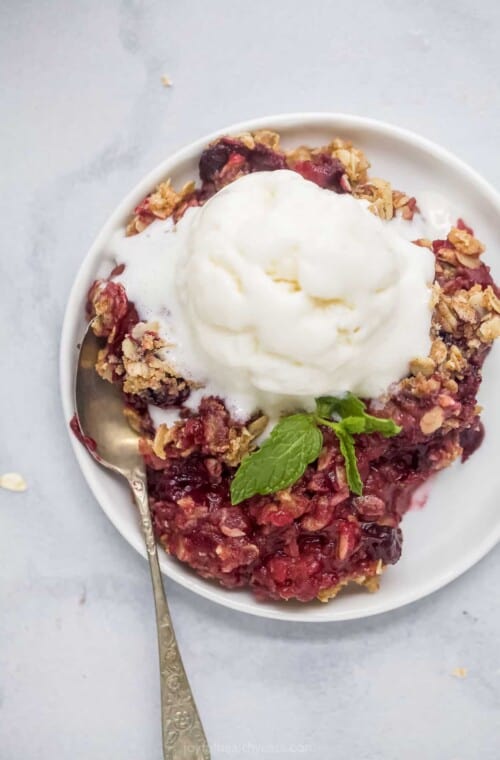 plate filled with apple blueberry crumble topped with ice cream