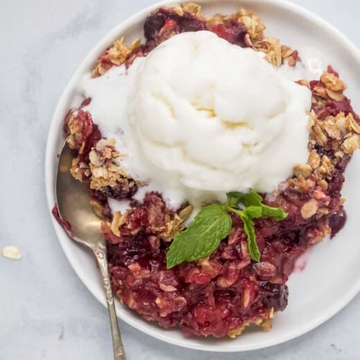 plate filled with apple blueberry crumble topped with ice cream