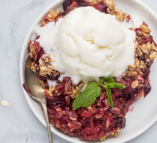 plate filled with apple blueberry crumble topped with ice cream