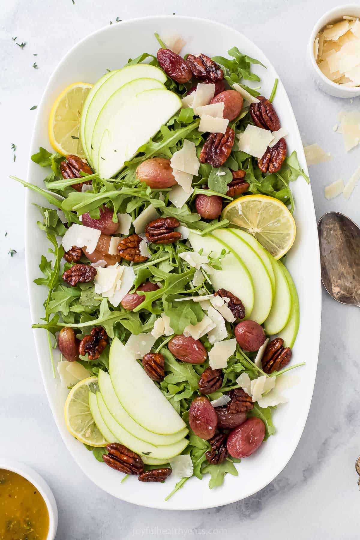 An overhead shot of a platter of arugula salad on a granite countertop