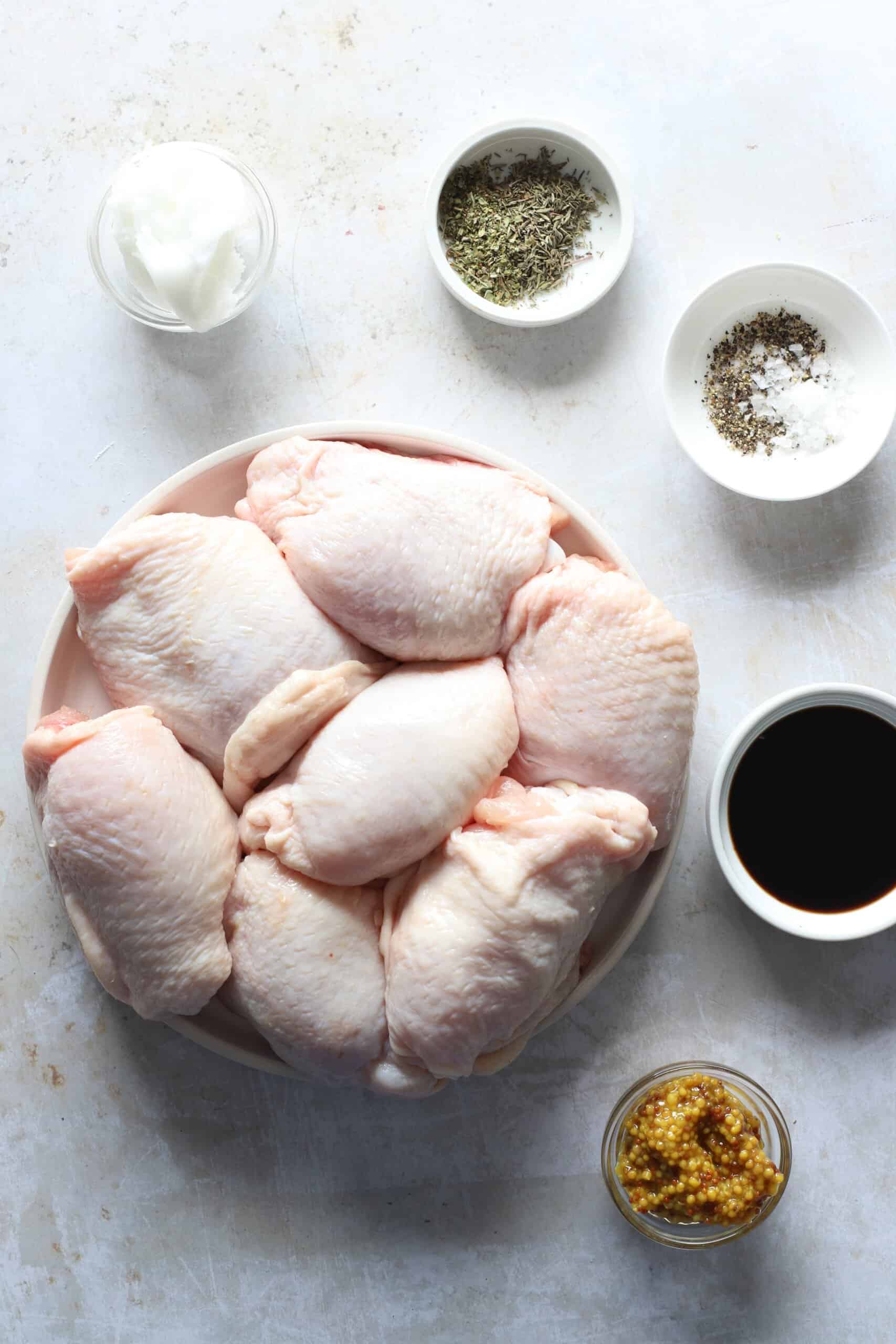 Raw chicken, stone ground mustard, balsamic vinegar and the remaining ingredients on a countertop