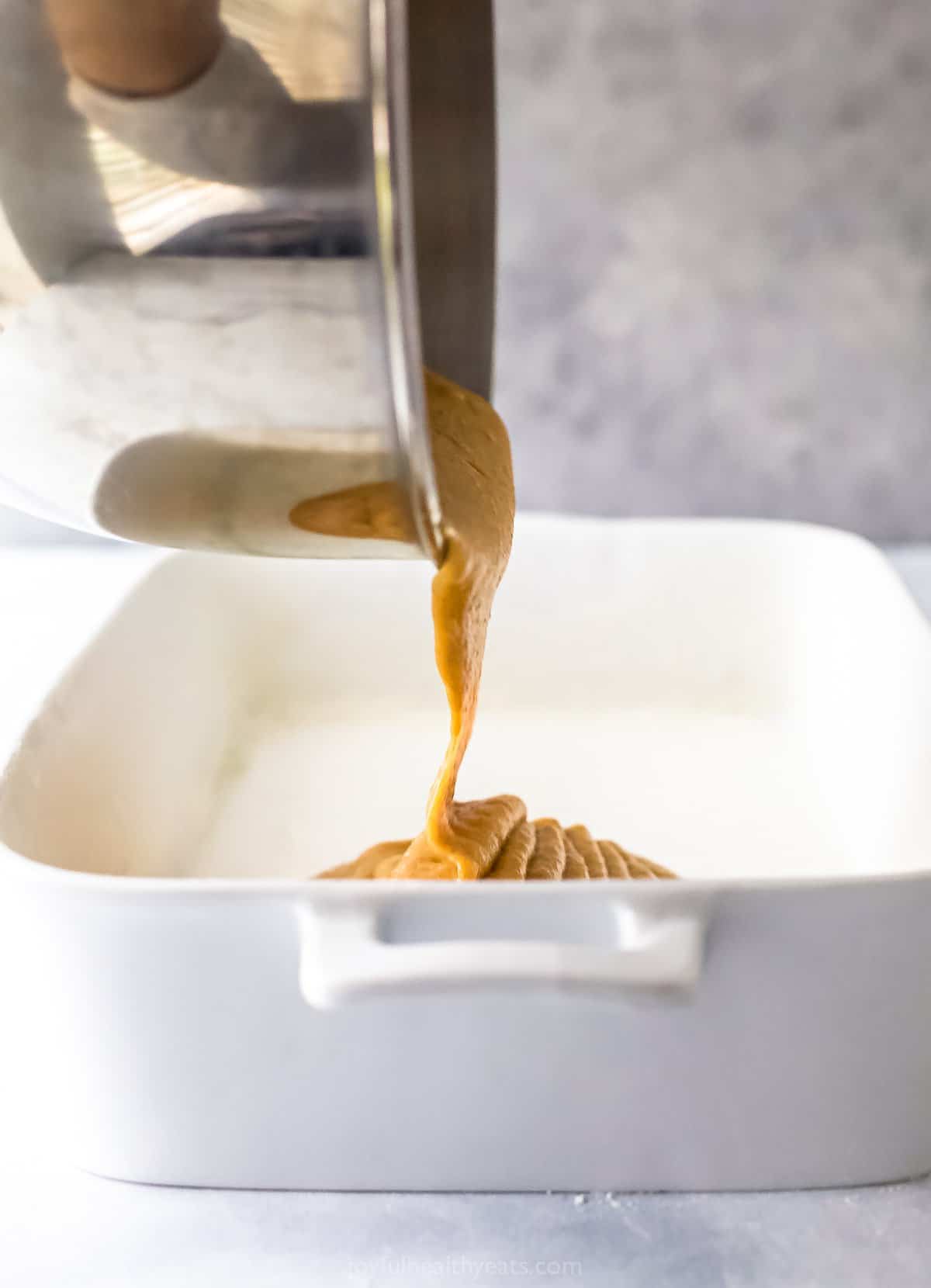 pumpkin coffee cake batter being poured into baking dish
