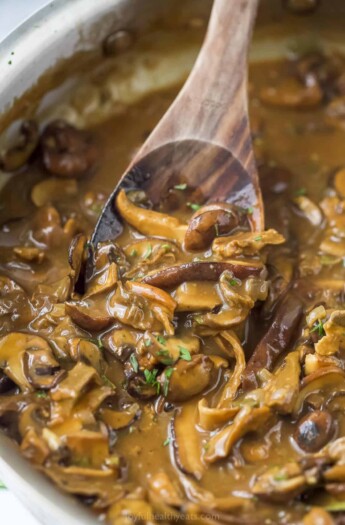 A wooden spoon digging into a pot of freshly-made mushroom gravy