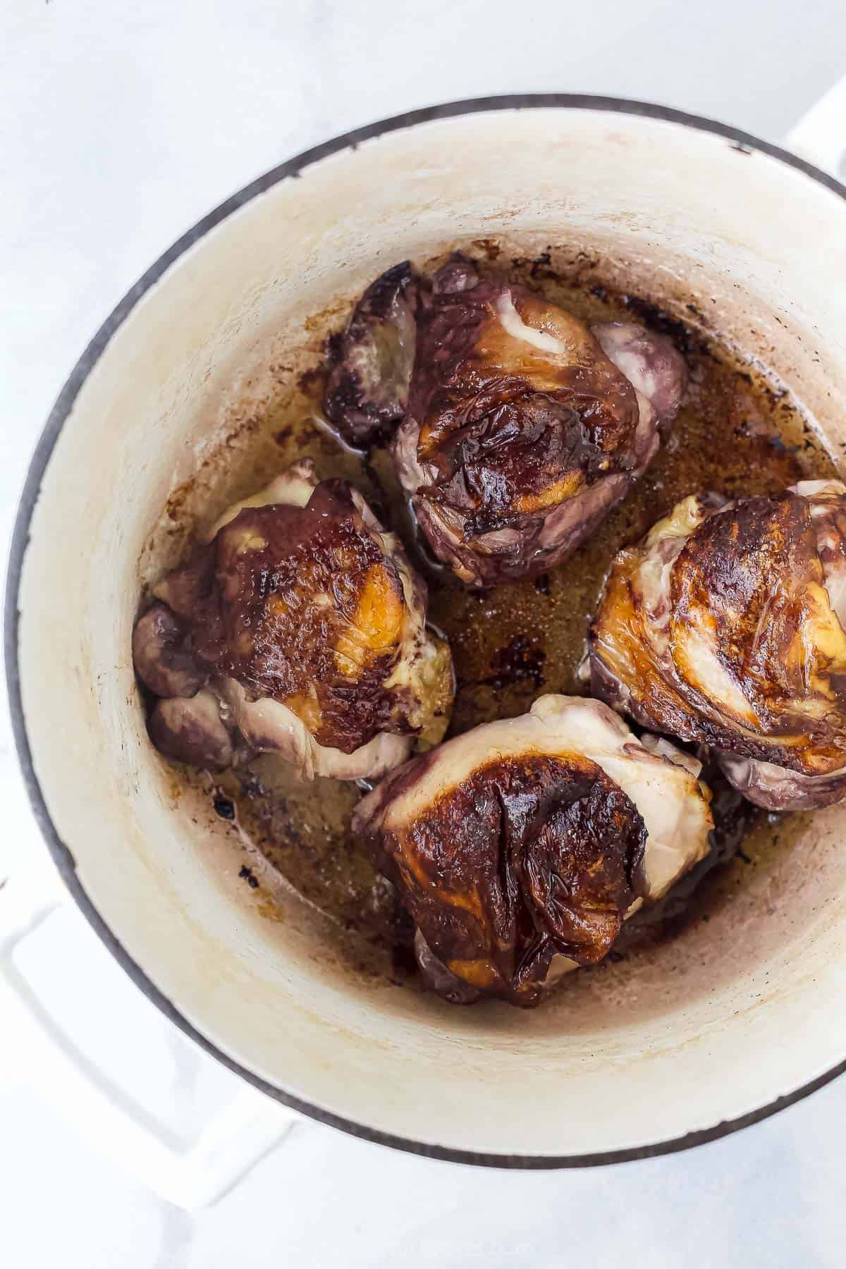 Wine-braised chicken simmering inside of a large dutch oven