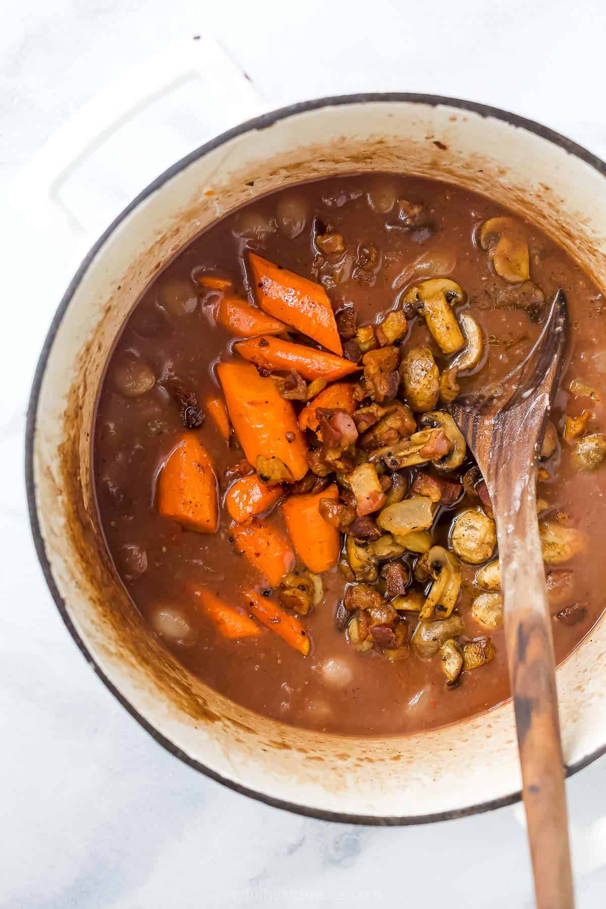 A pot of coq au vin chicken stew before it has been roasted in the oven