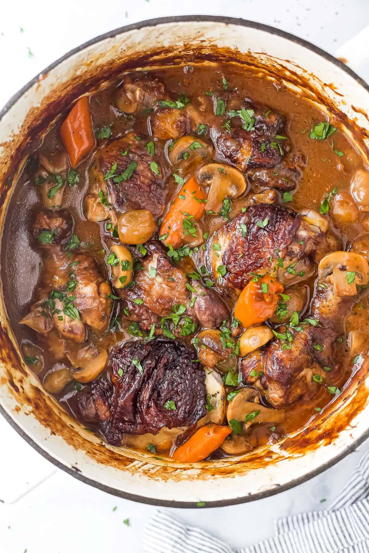 The bird's-eye view of a pot of coq au vin stew on a kitchen countertop