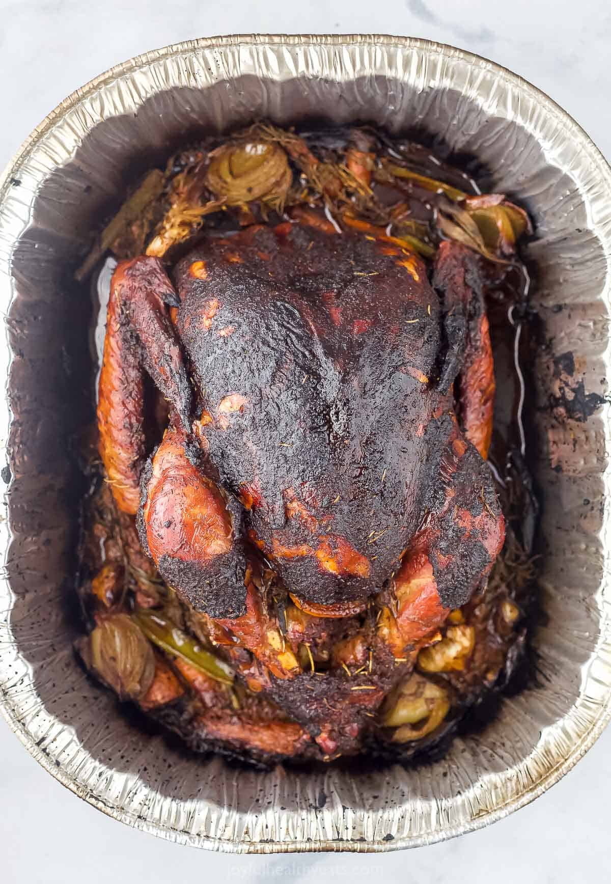 finished smoked turkey in a roasting pan