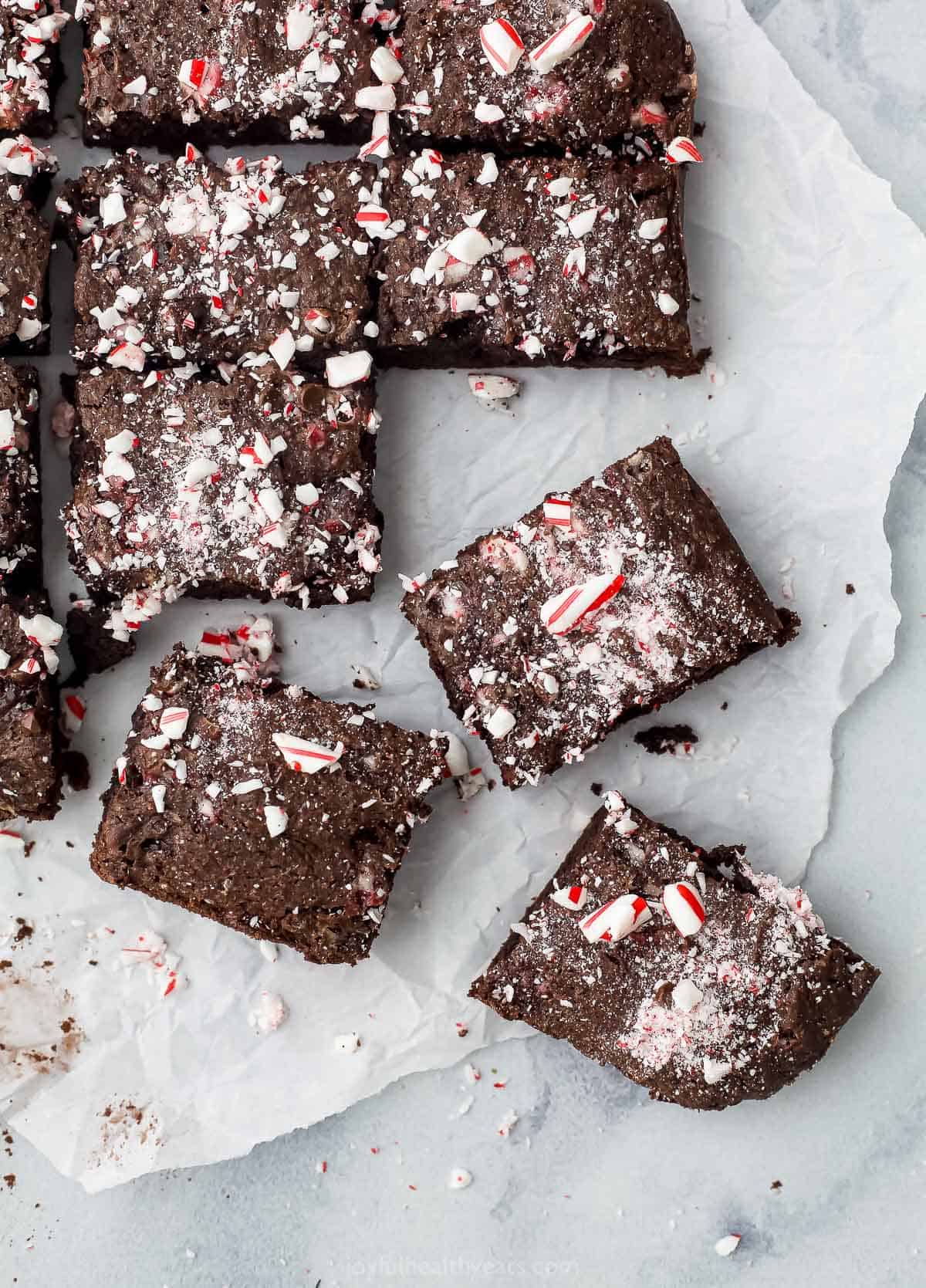 A batch of fudgy brownies on a piece of parchment paper over a marble surface