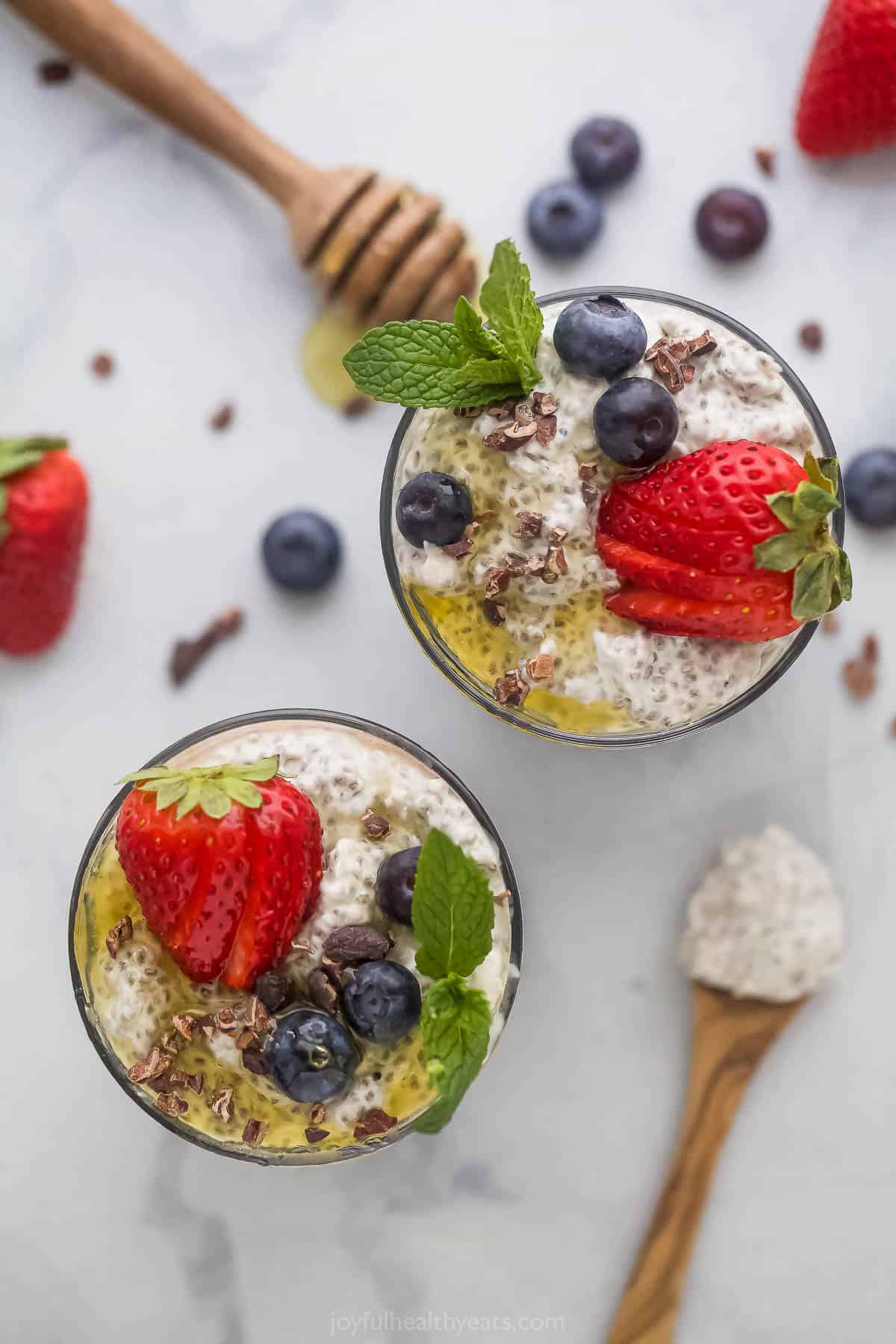 Two glasses filled with vanilla chia seed pudding on a marble countertop