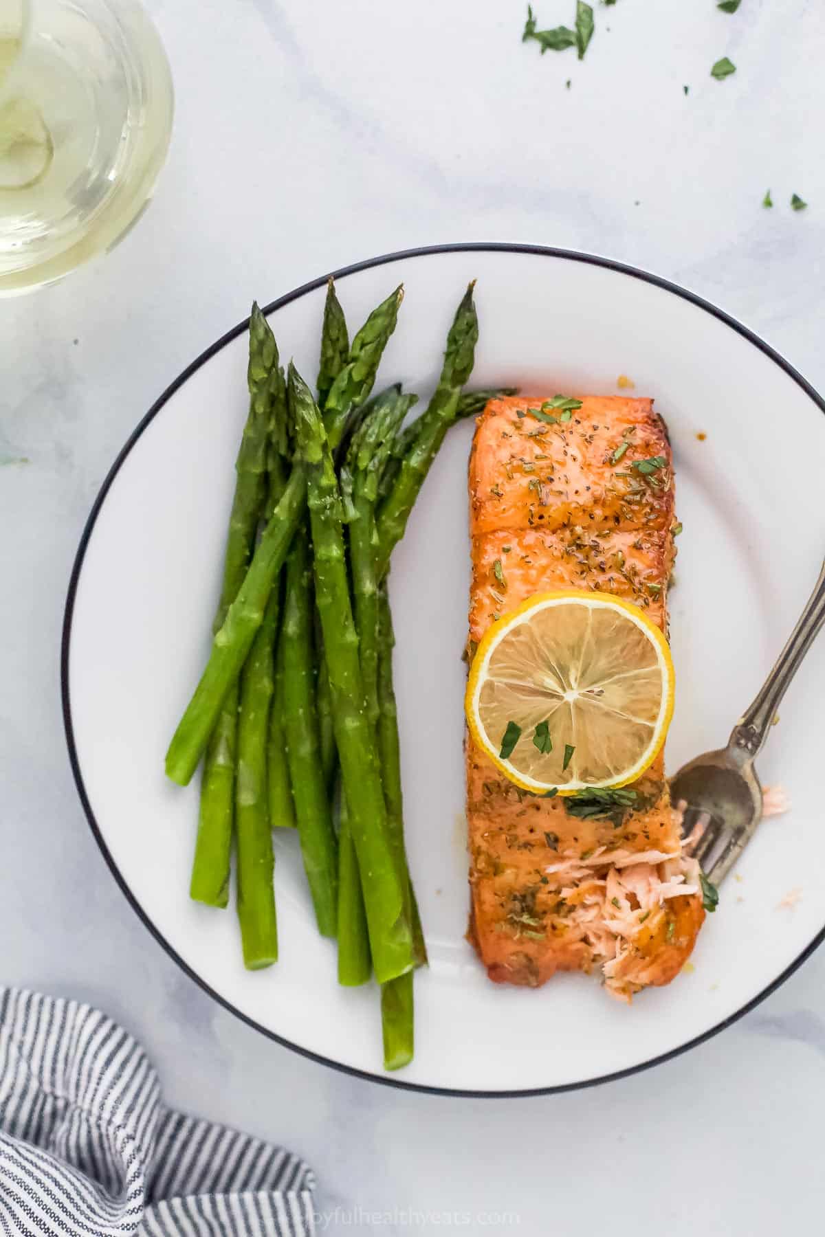 A white plate with air fryer salmon and asparagus.