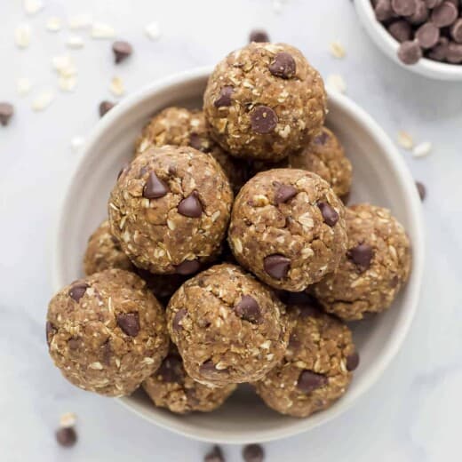 The bird's-eye view of a bowl of protein balls beside a smaller bowl filled with chocolate chips