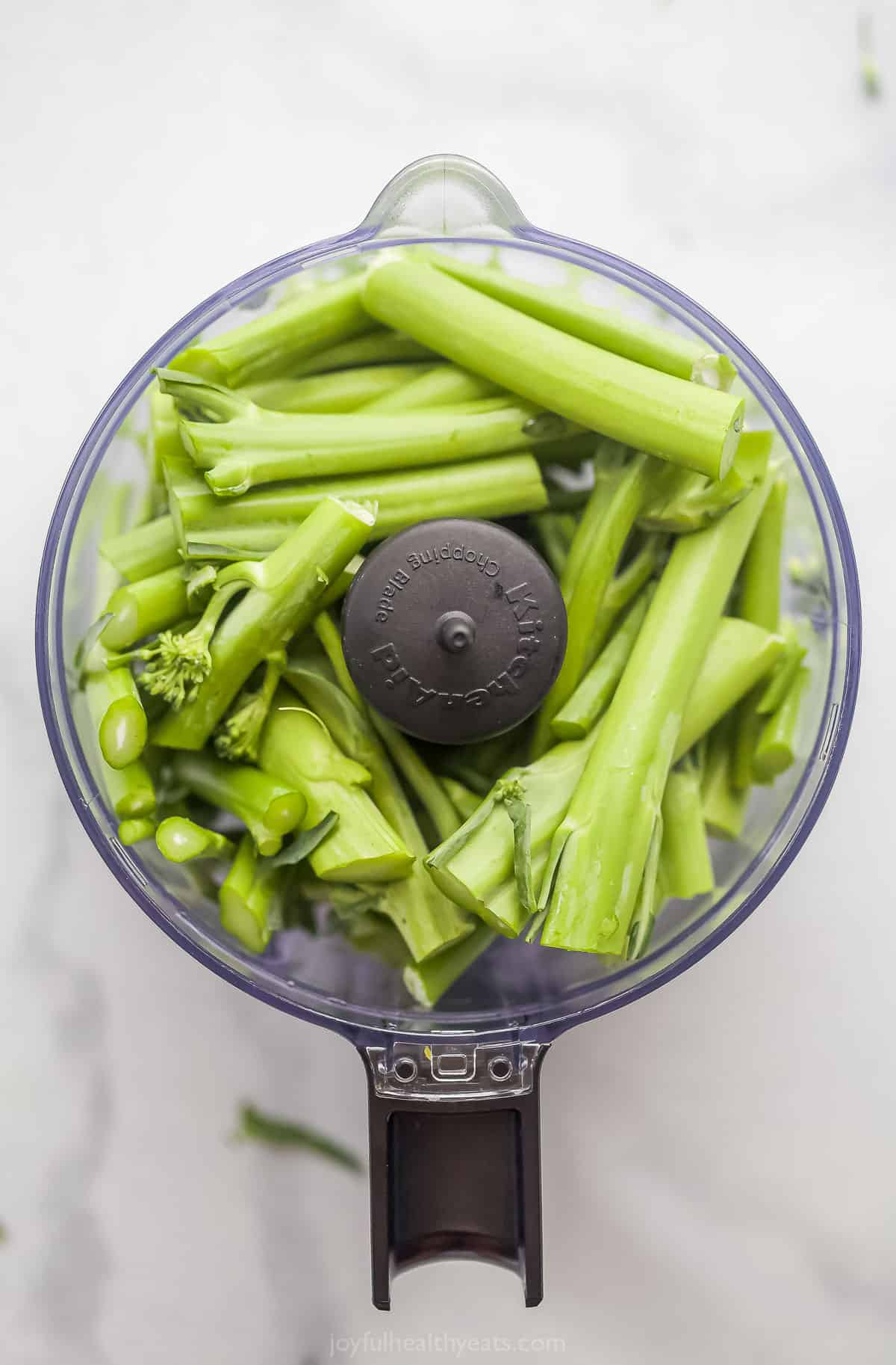 Broccolini stems inside of a small food processor