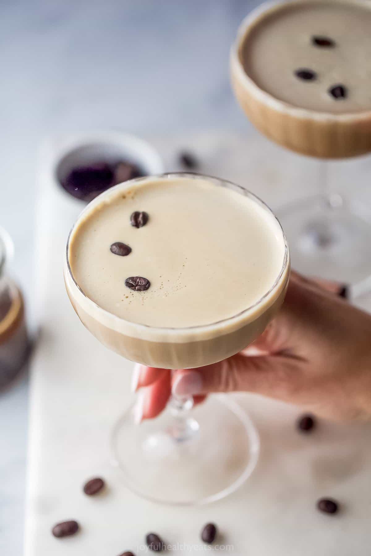 hand holding a glass filled with espresso martini