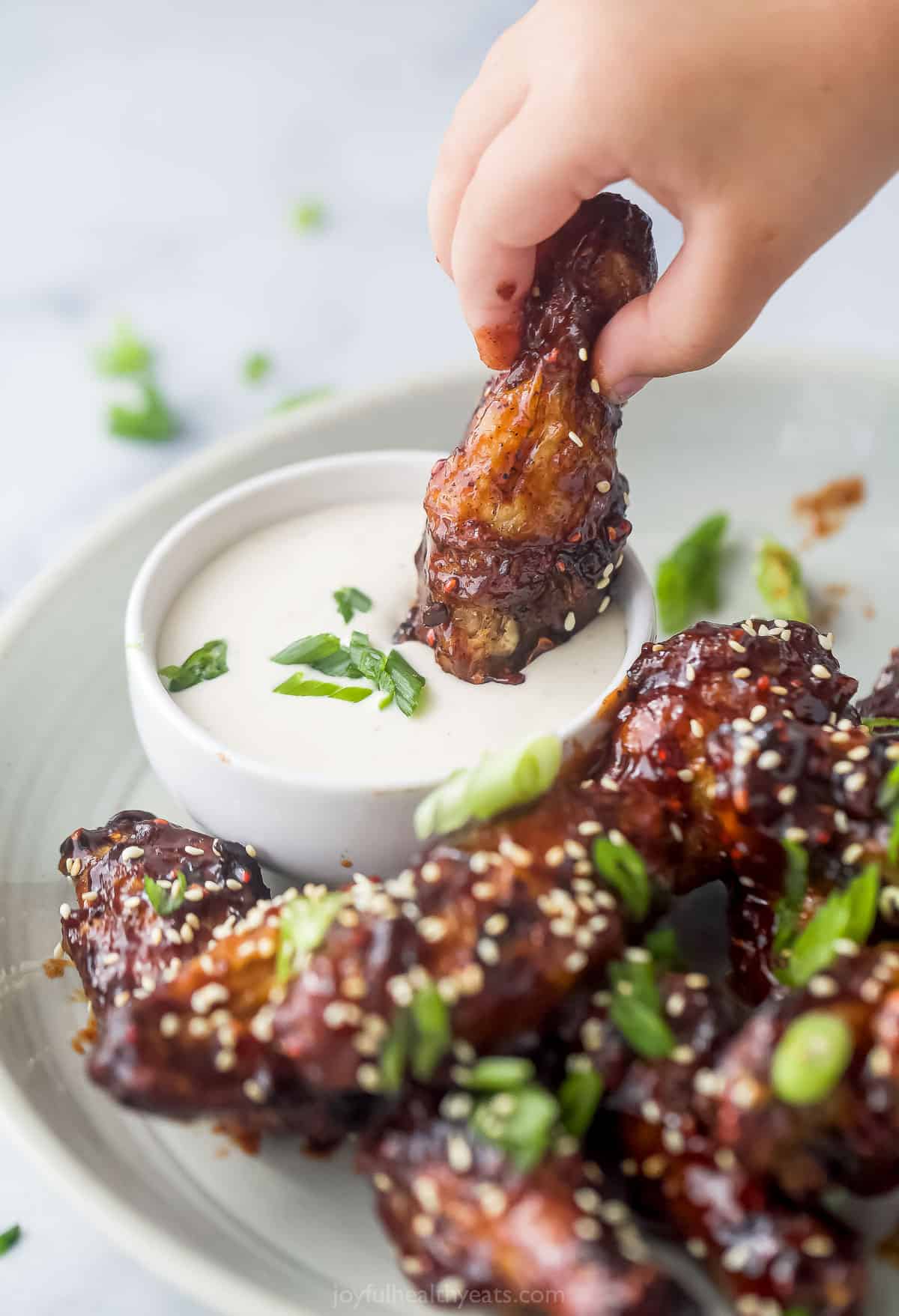 asian chicken wing being dunked into ranch