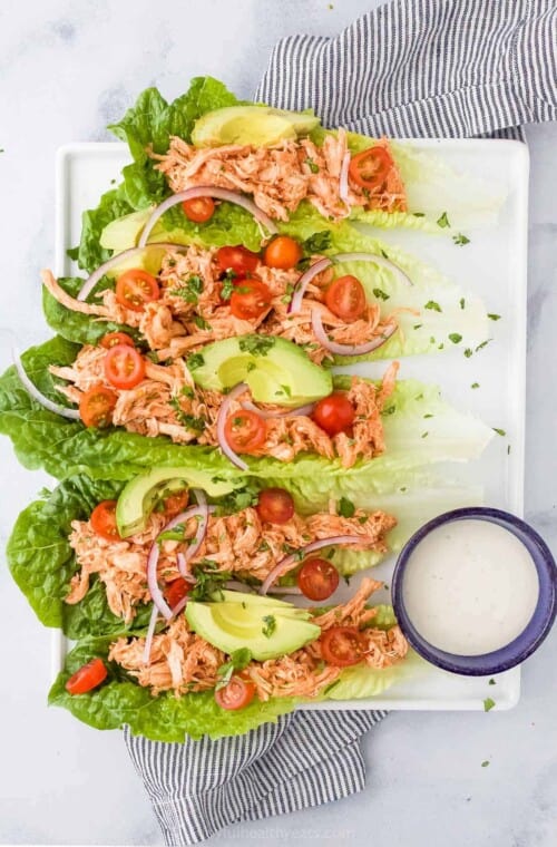 plate filled with buffalo chicken lettuce wraps and a cup with ranch