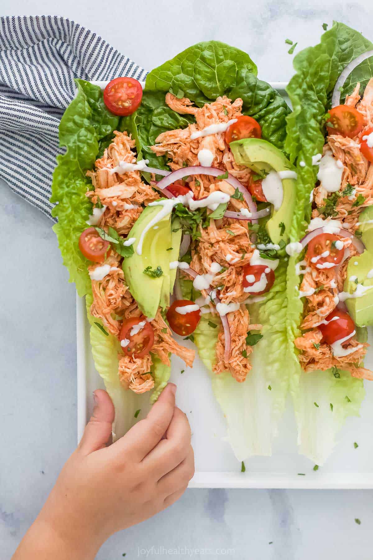 buffalo chicken lettuce wraps with a hand grabbing