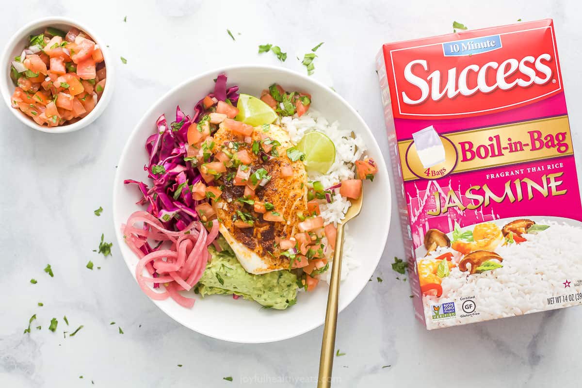 Baja Fish Taco Rice Bowls in a bowl with a spoon next to a box of success rice