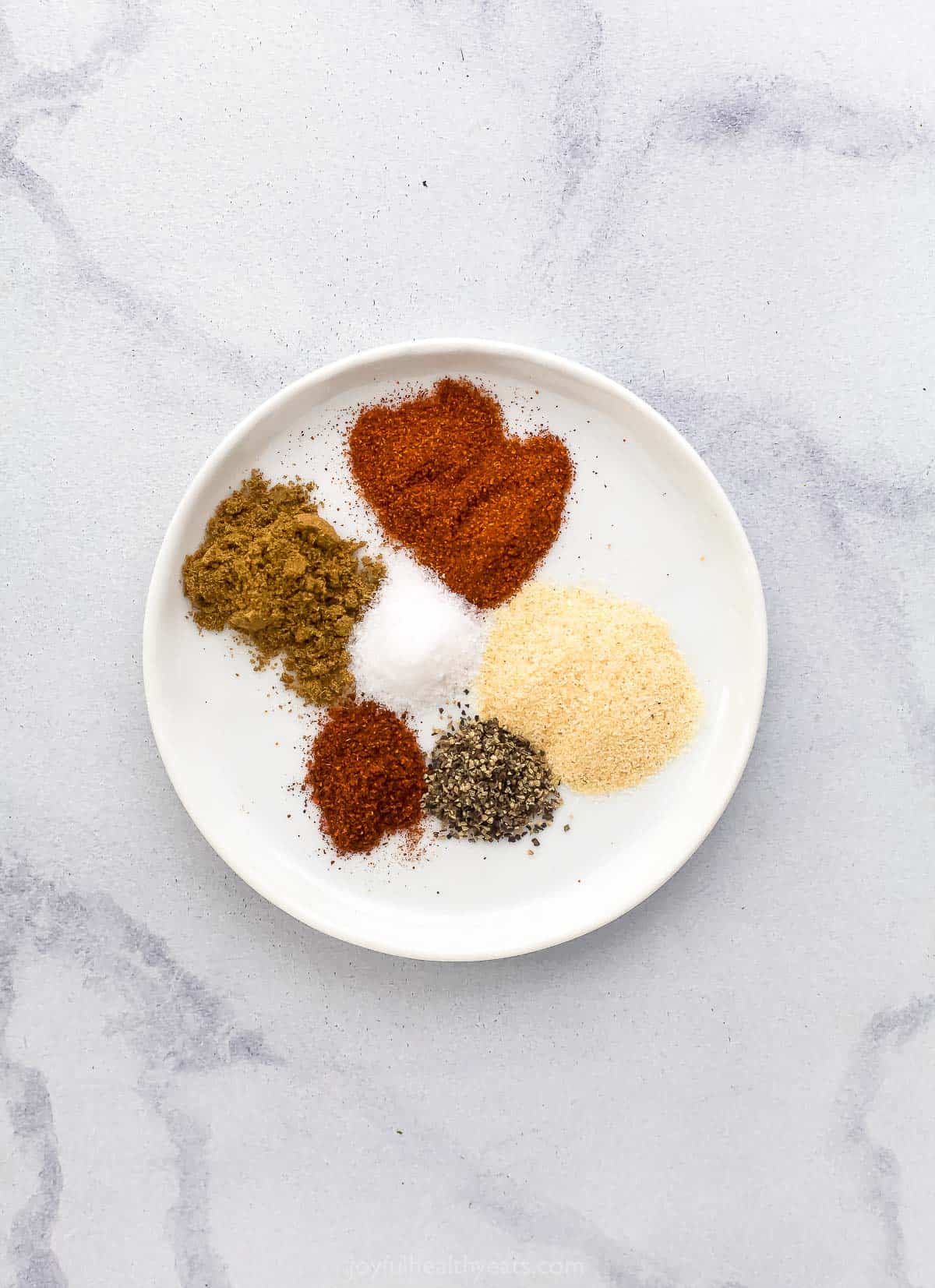 All of the cod seasonings on a small plate on top of a marble surface