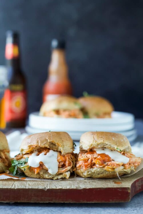 cheesy buffalo chicken sliders on a cutting board with ranch dressing