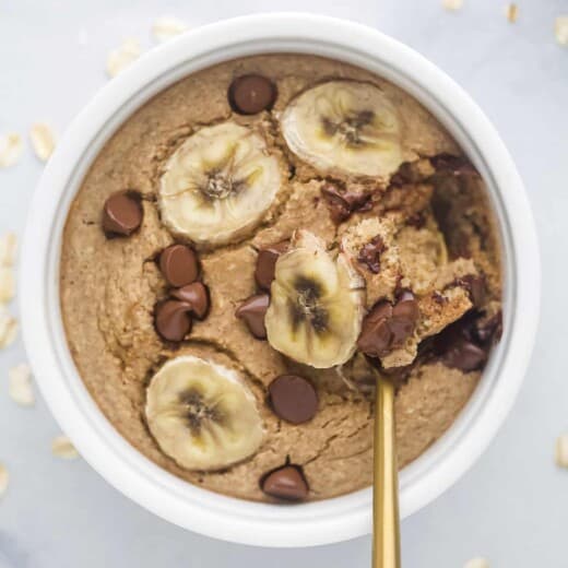A spoon scooping out a bite of chocolate peanut butter baked oatmeal from a ramekin