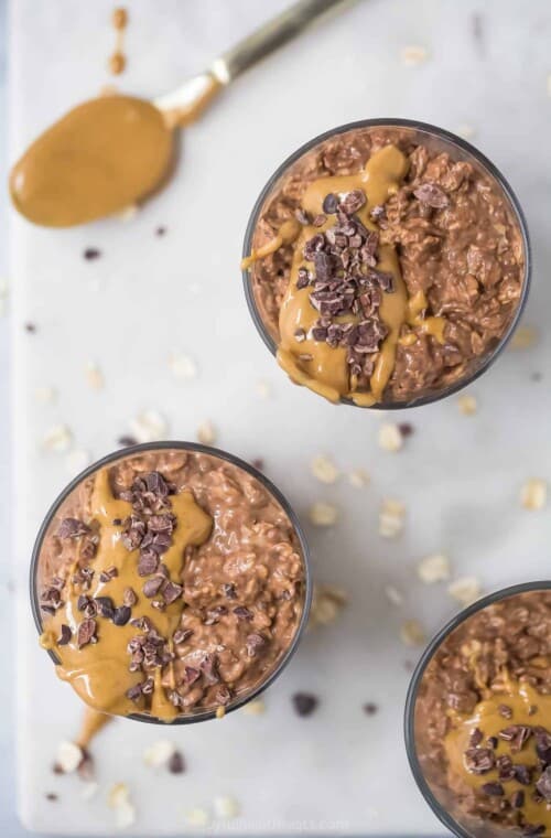 Overhead view of two glass cups of chocolate peanut butter overnight oats