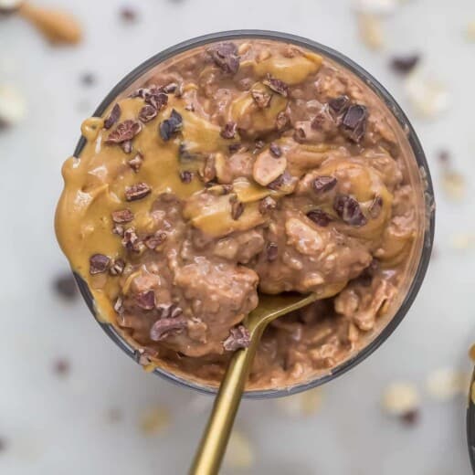 Overhead view of a dish of chocolate peanut butter overnight oats with a spoon