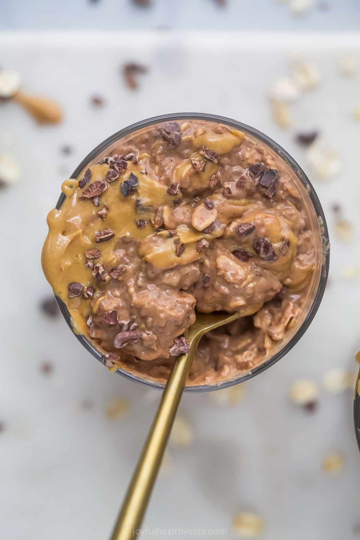 Overhead view of a dish of chocolate peanut butter overnight oats with a spoon