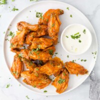 A plate of Air Fryer buffalo wings with a small dish of ranch beside them