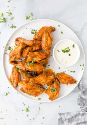 A plate of Air Fryer buffalo wings with a small dish of ranch beside them