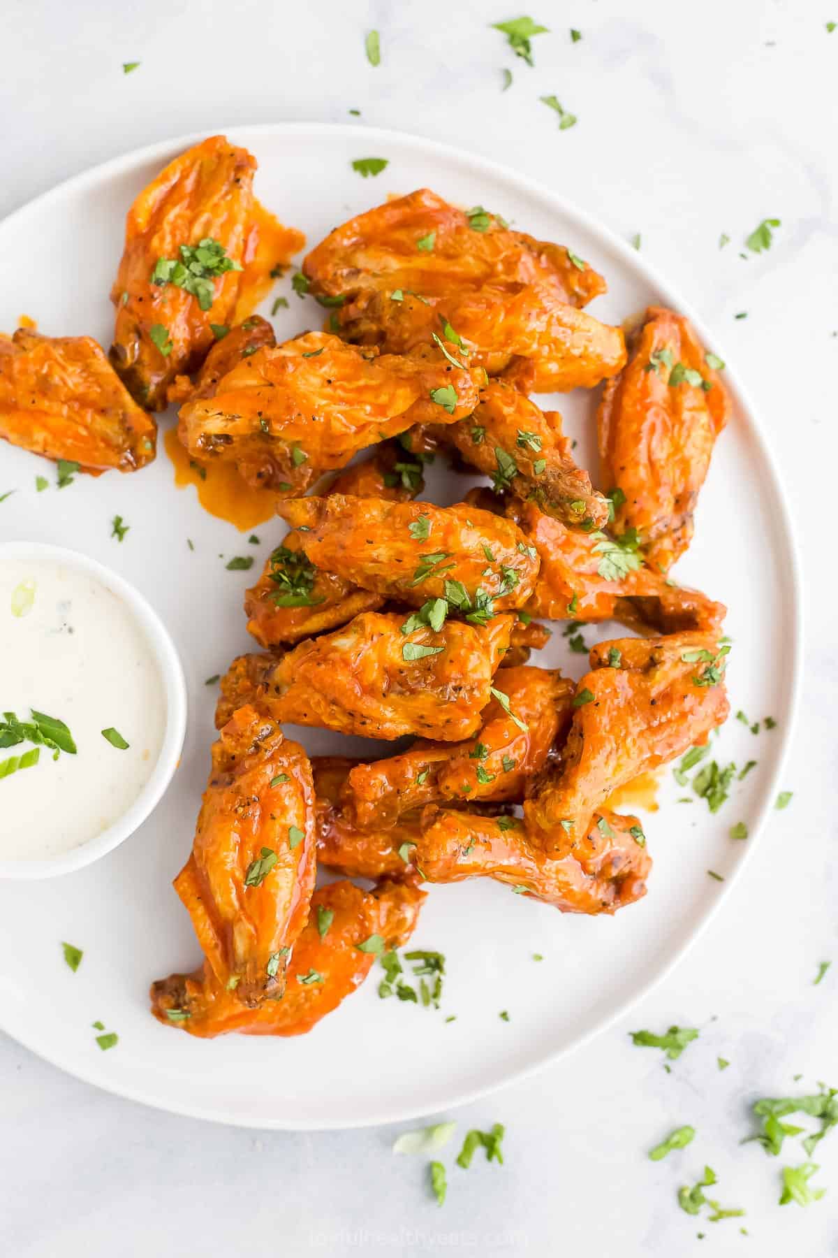 Air Fryer buffalo chicken wings on a plate on top of a granite countertop