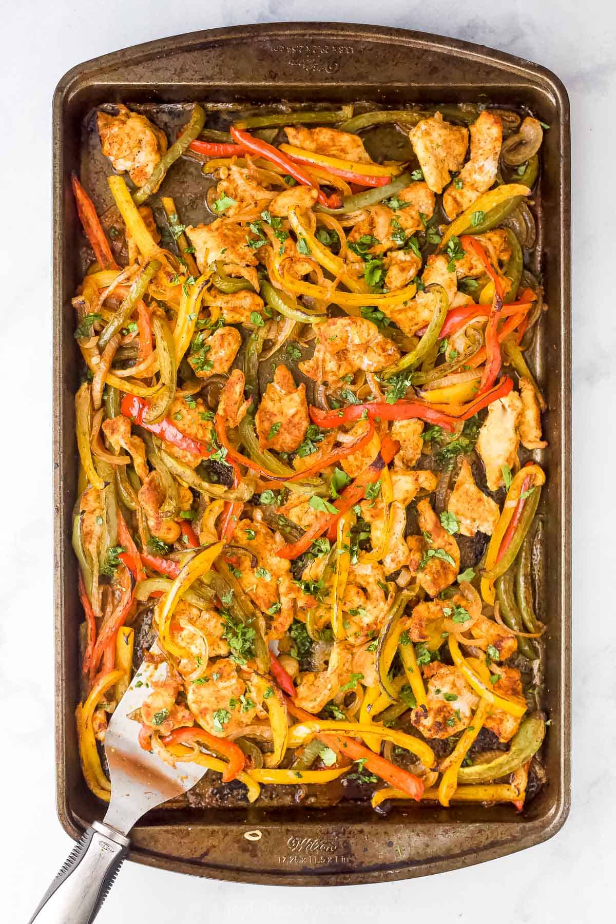 Overhead view of chicken fajitas on a baking sheet