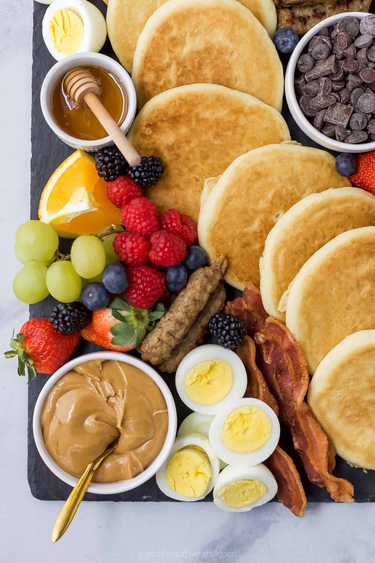 A close-up shot of a brunch charcuterie board with a line of pancakes down the middle