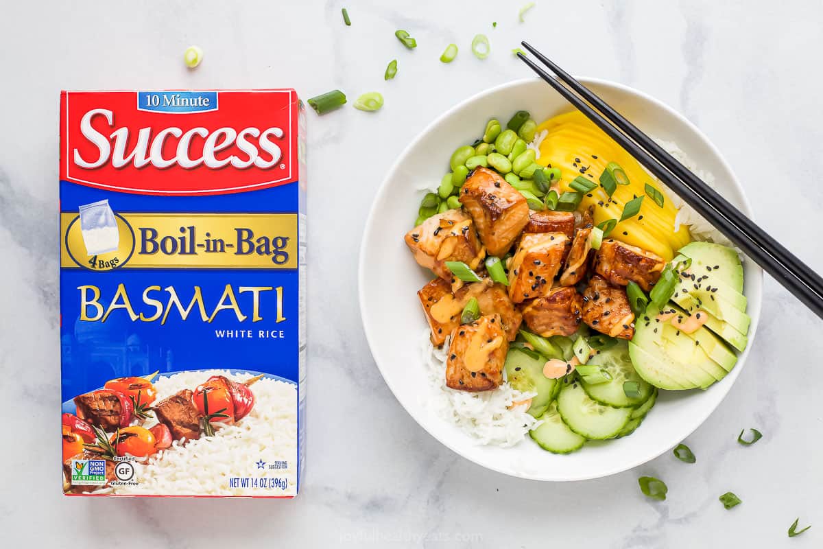 A salmon poke bowl beside a bag of Success Boil-in-Bag basmati rice